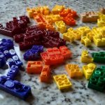 Close-up of colorful LEGO bricks stacked together, showing the quality and precision that contribute to their high cost
