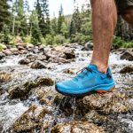 Person wearing affordable water shoes by a Colorado mountain lake.