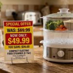 Stainless steel electric food steamer cooking fresh vibrant vegetables on a kitchen counter.
