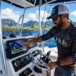 Modern fish finder screen displaying fish arches in clear Hawaiian waters.