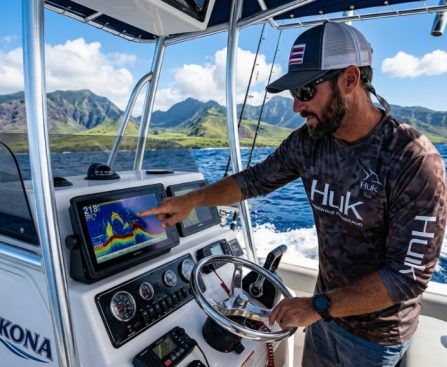 Modern fish finder screen displaying fish arches in clear Hawaiian waters.